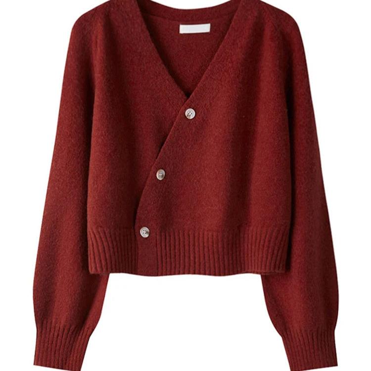 Alora trui in een warme bordeauxrode kleur met een moderne asymmetrische knoopsluiting. De trui heeft lange mouwen, een brede ribgebreide taille en een comfortabele pasvorm. Ideaal voor een stijlvolle en eigentijdse uitstraling.
