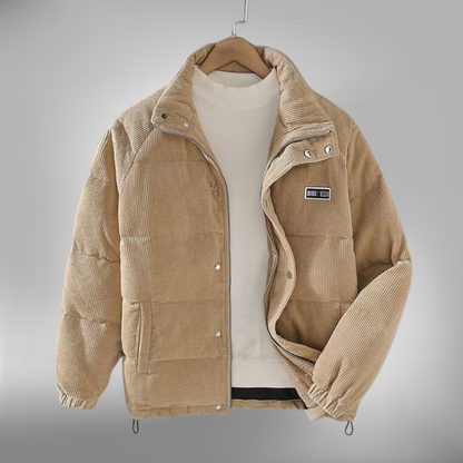 De Borealis winterjas in beige corduroy biedt zowel stijl als comfort tijdens de koude maanden. Deze gewatteerde jas is voorzien van een ritssluiting en drukknopen voor extra bescherming tegen de kou. Met een subtiele merkpatch op de borst en een verstelbare onderrand, is deze jas ideaal voor dagelijks gebruik in de winter. Het ontwerp is veelzijdig en zorgt voor een warme en modieuze uitstraling.