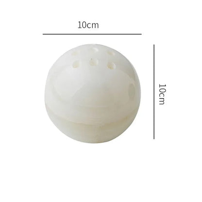 Grazia wierookhouder met rustgevend ontwerp, gemaakt van gepolijst wit marmer. De bolvormige houder heeft een diameter van 10 cm en is voorzien van meerdere gaten voor wierookstokjes. Een stijlvolle en kalmerende toevoeging aan elk interieur.