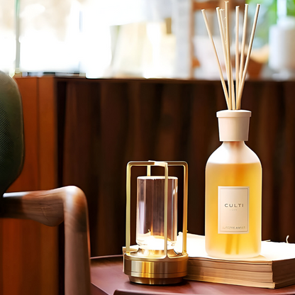 Jovien waterdichte lamp op een tafel, naast een decoratieve geurstokjeshouder, met een warme gloed die een gezellige sfeer creëert. De lamp heeft een elegante metalen afwerking en is perfect voor binnengebruik.