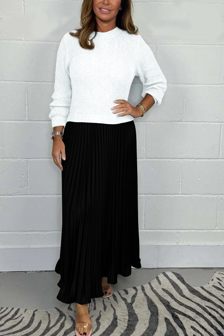 Een stijlvolle, tijdloze pleated jurk van Kendra in zwart, gecombineerd met een witte trui-top. De elegante plissé rok voegt een verfijnde uitstraling toe, perfect voor een casual-chique look.