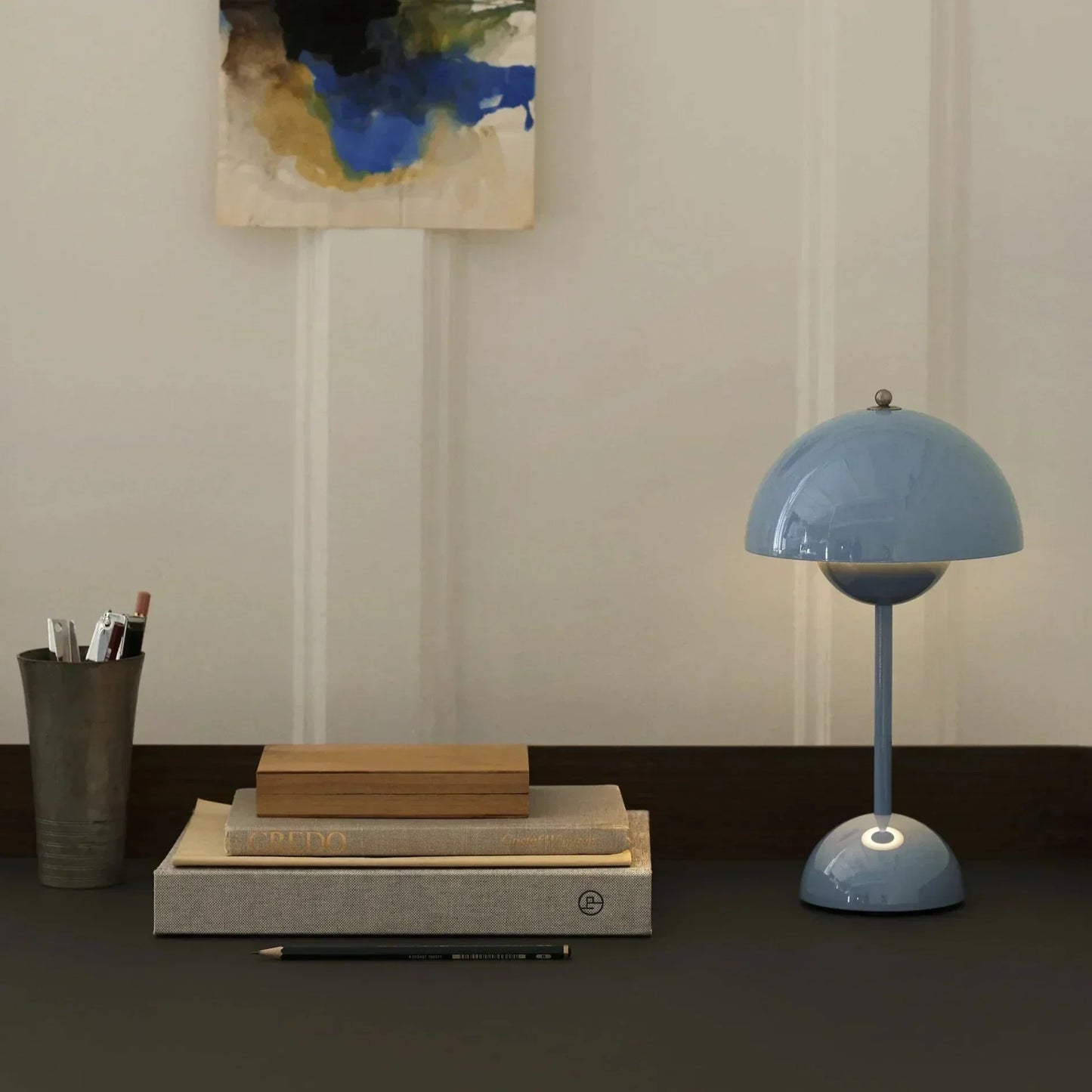 LumenShine LED Tafellamp in een elegante lichtblauwe afwerking, stijlvol gepresenteerd op een minimalistisch bureau met boeken en accessoires. Deze energiezuinige en moderne lamp biedt een verfijnde verlichting voor werk- of woonruimtes.