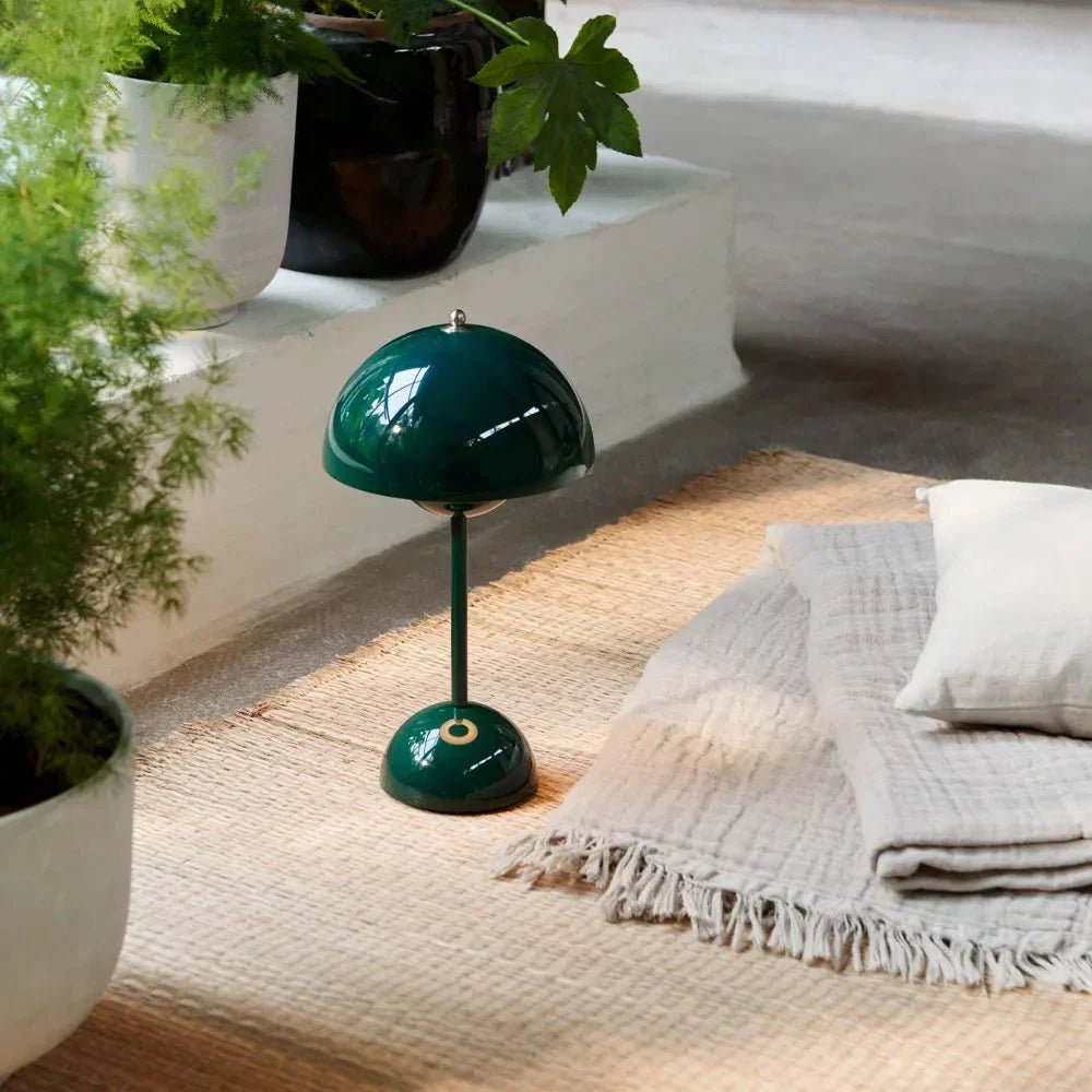 LumenShine LED Tafellamp in een stijlvolle donkergroene uitvoering, geplaatst in een serene en natuurlijke setting. Perfect voor energiezuinige verlichting met een modern design, ideaal om sfeer te creëren in elke ruimte.