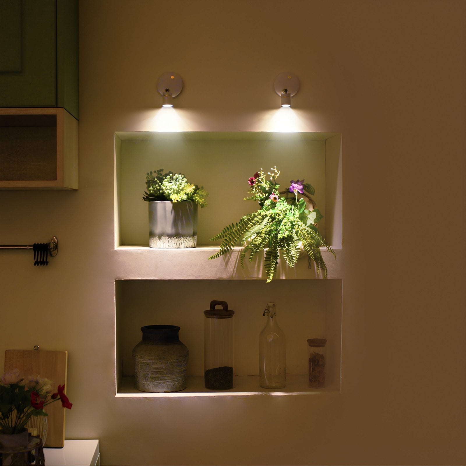 Twee energiezuinige LumiaPro spotlights verlichten zorgvuldig geplaatste planten op een schap in een keuken, waarbij een warme, sfeervolle gloed wordt gecreëerd in de ruimte.