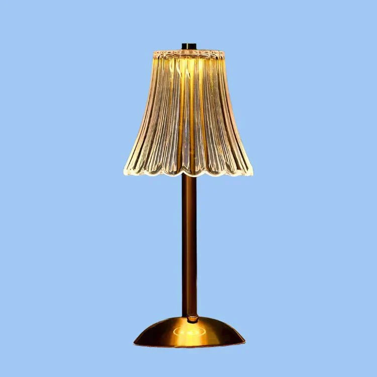 Een stijlvolle draadloze tafellamp met een gouden voet en een prachtig geplooide glazen lampenkap die warm gloeit, waardoor een elegante en moderne sfeer in elke kamer ontstaat.