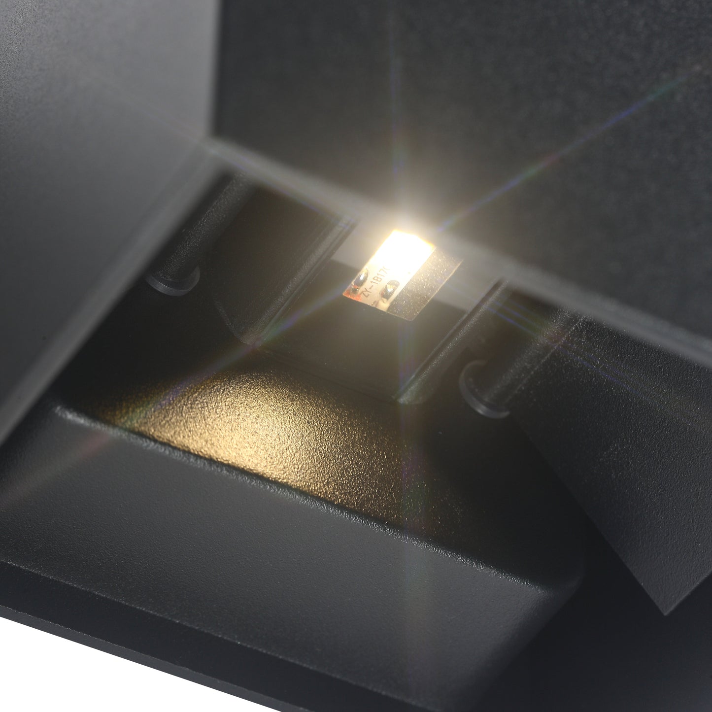 Close-up van de LED-verlichting binnen de Quinova wandlamp, met een helder licht dat uitstraalt van een klein, ingebouwd LED-paneel in een strakke, vierkante zwarte behuizing.