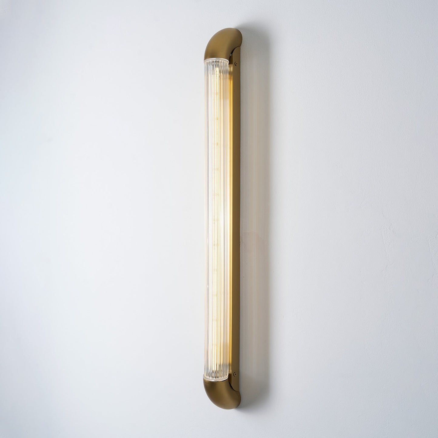 Wandlamp met Geribbelde Glazen Buis en Gebogen Roestvrijstalen Accenten | Moderne Verlichting met Geïntegreerde LED
