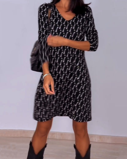 Diamond print v-hals jurk in de kleur Zwart voor dames in stijl ideaal voor de herfst.