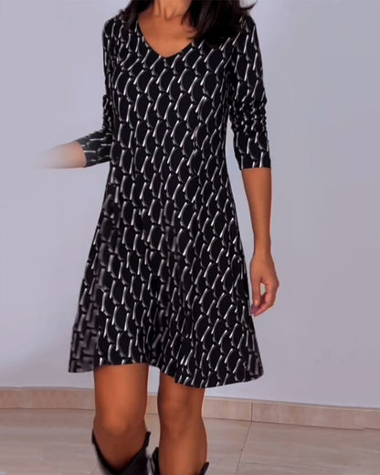 Diamond print v-hals jurk in de kleur Zwart voor dames in stijl ideaal voor de herfst.